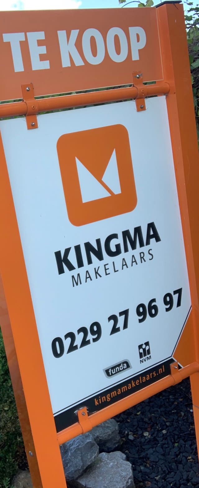 Oranje te-koopbord van een makelaar