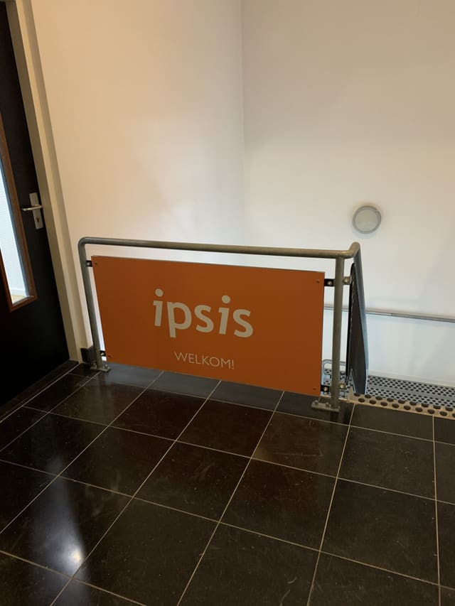 Oranje welkomstbord met logo aan een balustrade