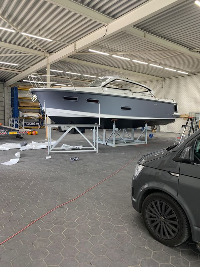 Motorboot met een donkergrijze romp op de bok in de loods