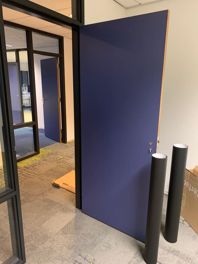 Openstaande deur in donkerblauwe folie in een kantoor