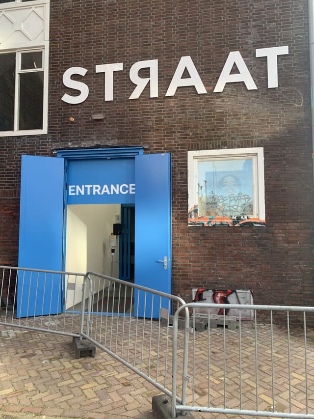 Grote letters boven de entree van een museum in een oude loods