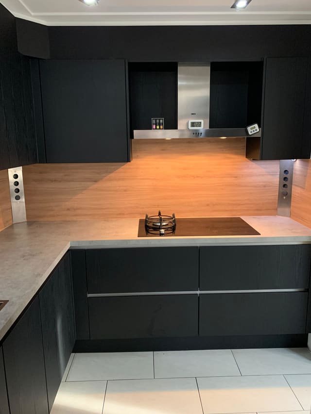 Zwarte keuken met een achterwand in houtlook