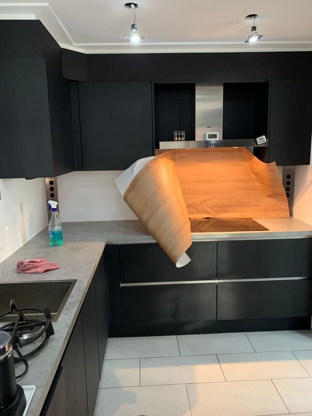 Houtlook-folie wordt op de achterwand van een keuken aangebracht