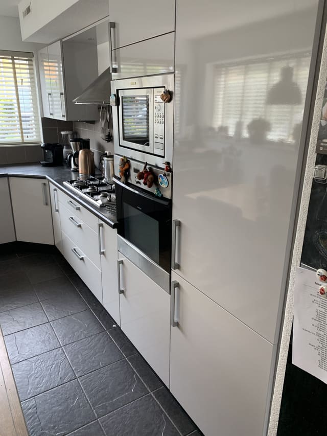 Witte hoogglanskeuken met hoge kasten