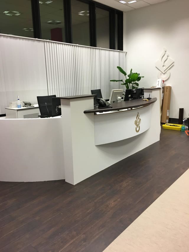 Witte receptiebalie in folie met een donker blad en een goudkleurig logo op de voorkant