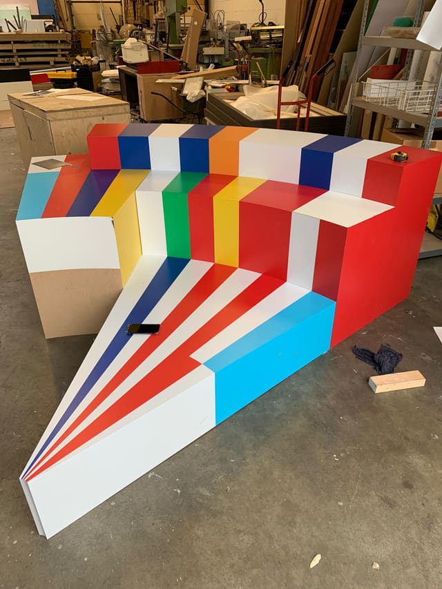 Zittribune in de werkplaats, gewrapt met strepen in rood, blauw, geel, groen en oranje
