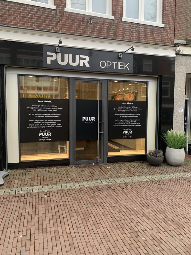 Winkelpui van een opticien met belettering op ramen en deur