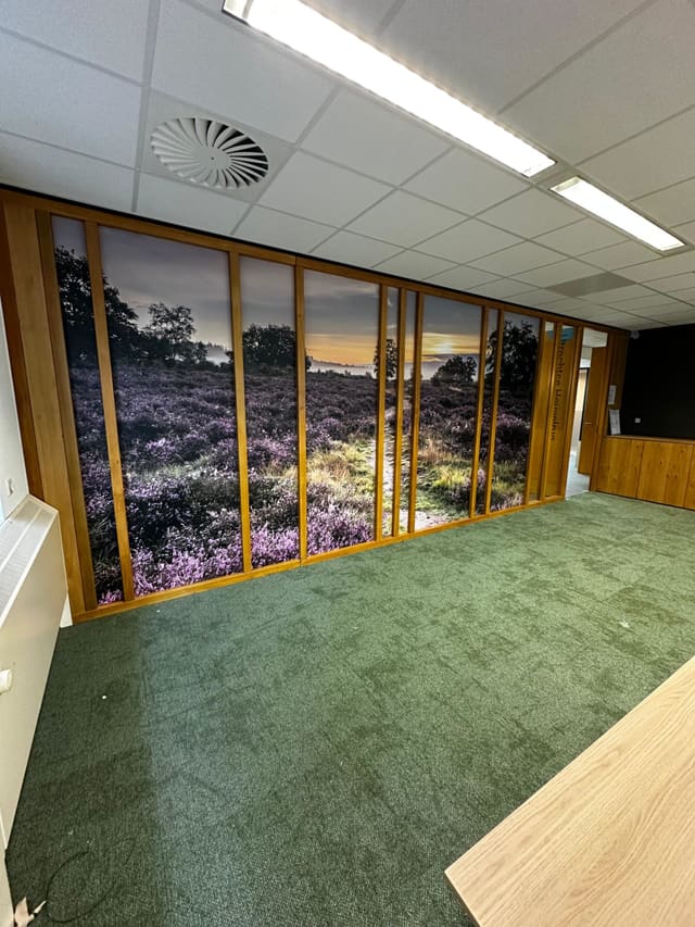 Glazen wand met een fotoprint van een heidelandschap