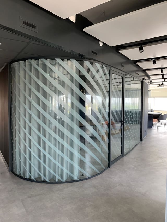 Ronde glazen wand met diagonale strepen van matte folie
