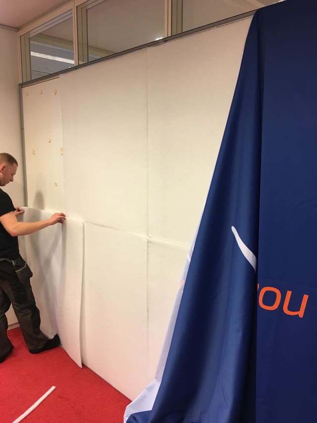 Montage van een smartframe: witte platen worden in het frame gezet, het bedrukte doek hangt klaar