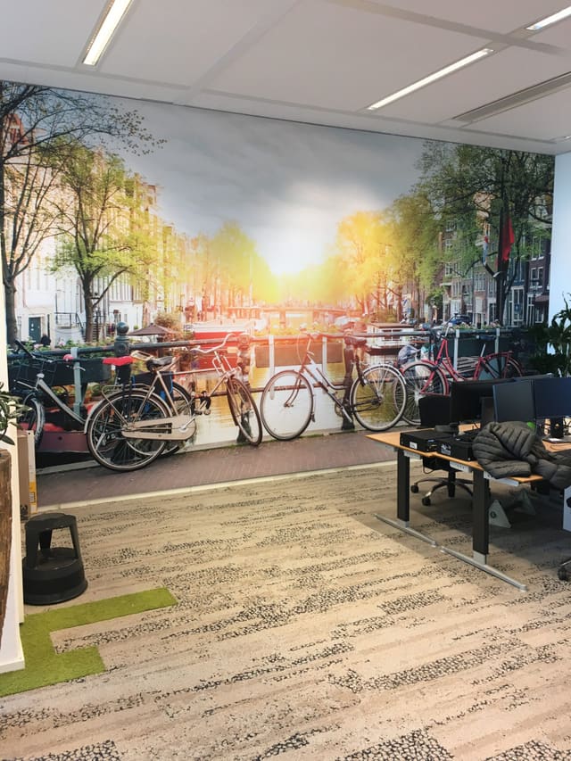 Smartframe met een zonnige grachtenfoto met fietsen in een kantoor
