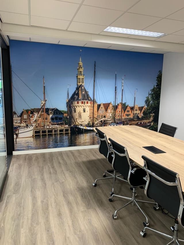 Vergaderkamer met een wandvullende foto van de Hoofdtoren en de haven van Hoorn