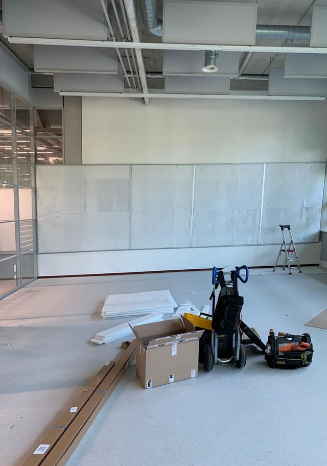 Lege kantoorruimte met de frames al op de wand, vóór het spannen van het doek