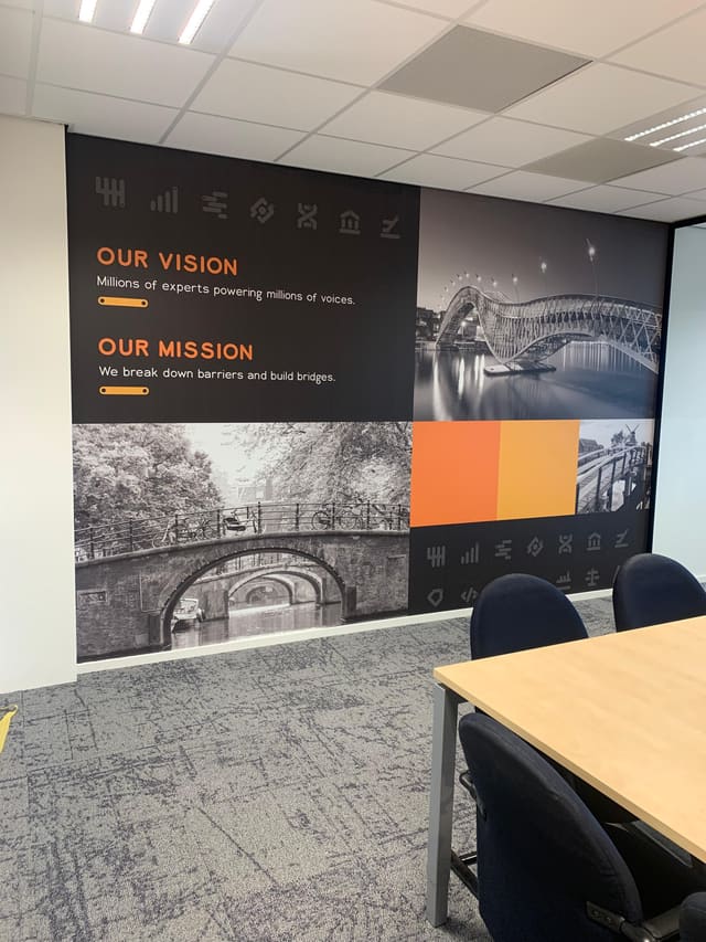 Wand met zwart-witfoto’s van bruggen en de teksten ‘Our vision’ en ‘Our mission’