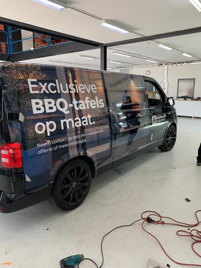 Zwarte bedrijfsbus met full-colour wrap voor BBQ-tafels op maat