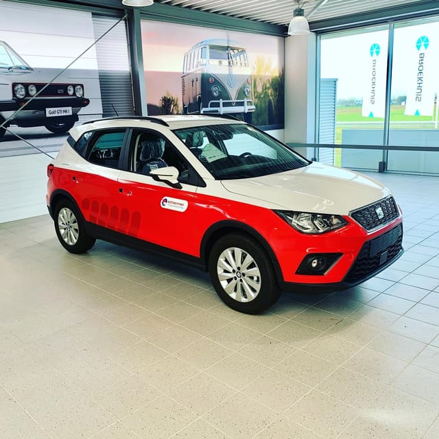 Rood-witte Seat met bedrijfsbelettering in een showroom