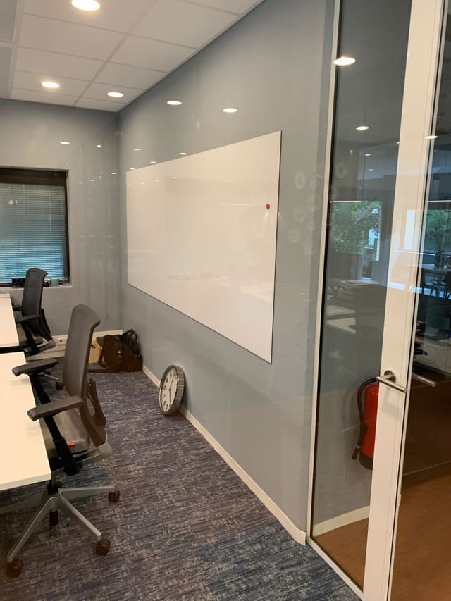 Whiteboard op een wand naast een glazen deur